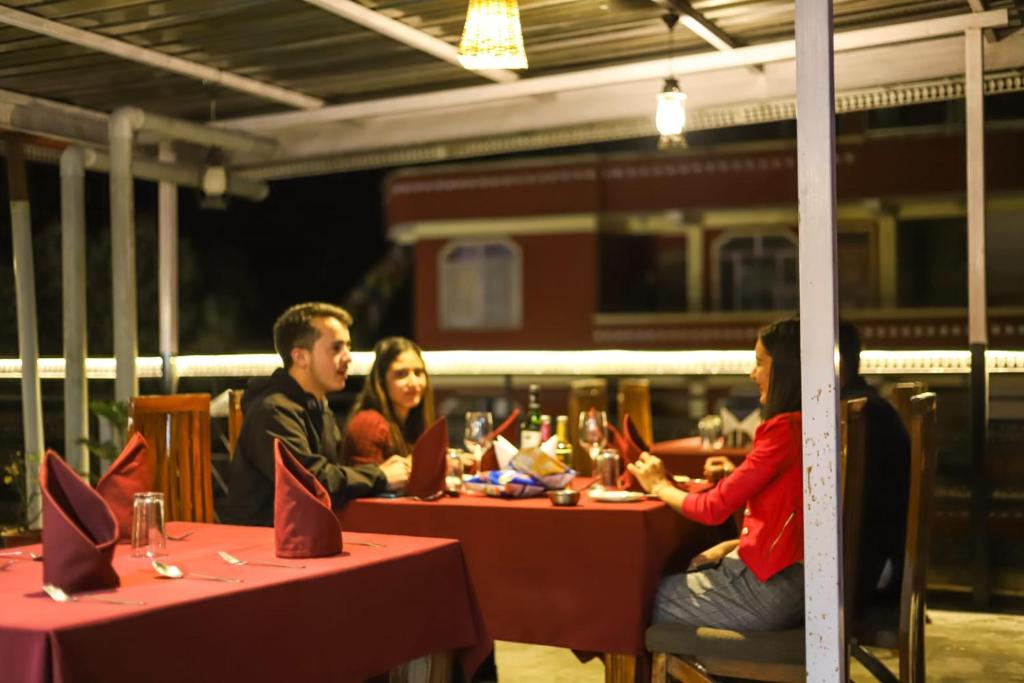 a group of people sitting at tables in a train station at Hotel Varuni- On Mall Road, Mcleod Ganj, Dharamshala in Dharamshala