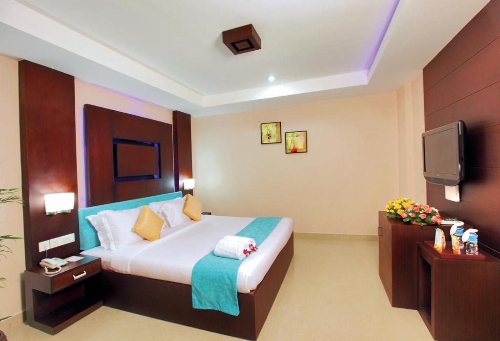 Habitación de hotel con cama y TV en HOTEL SRIVATSA REGENCY, en Pudunagaram