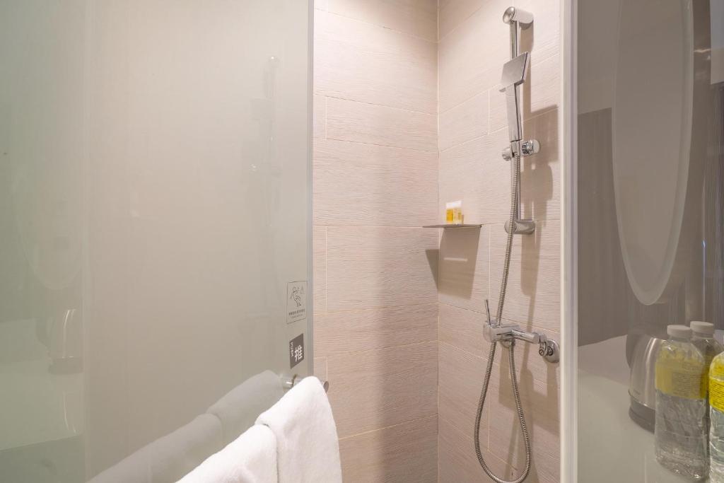 a bathroom with a shower with a glass door at CHECK inn Taipei Xinyi in Taipei