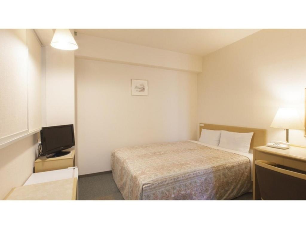 a small hotel room with a bed and a television at Green Hotel Kitakami - Vacation STAY 09833v in Kitakami