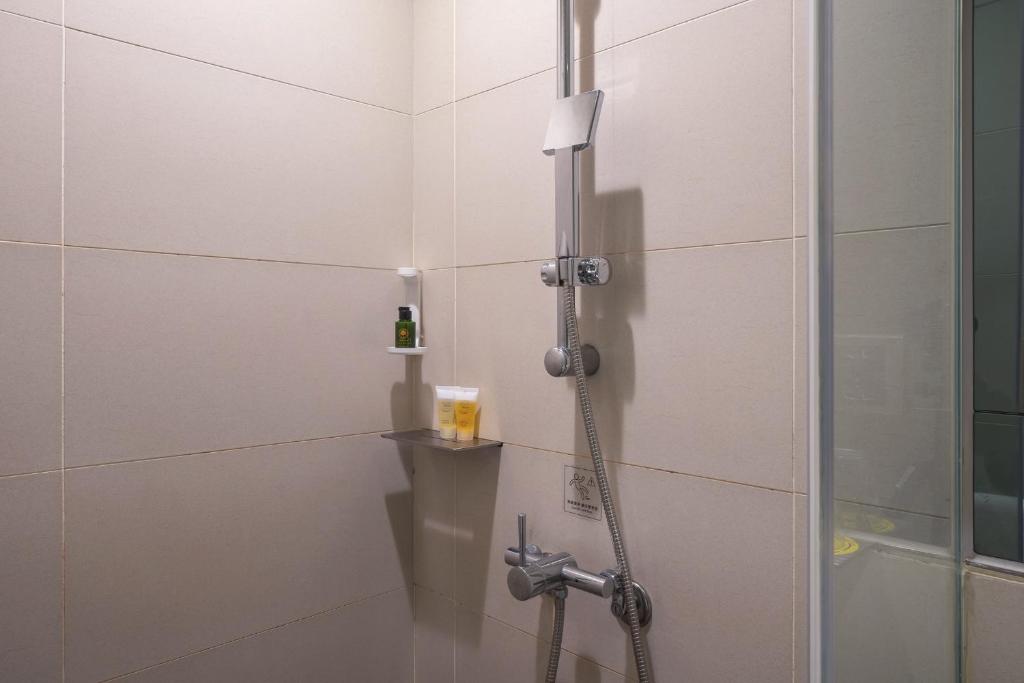a shower with a hose in a bathroom at CHECK inn Taipei Xinyi in Taipei