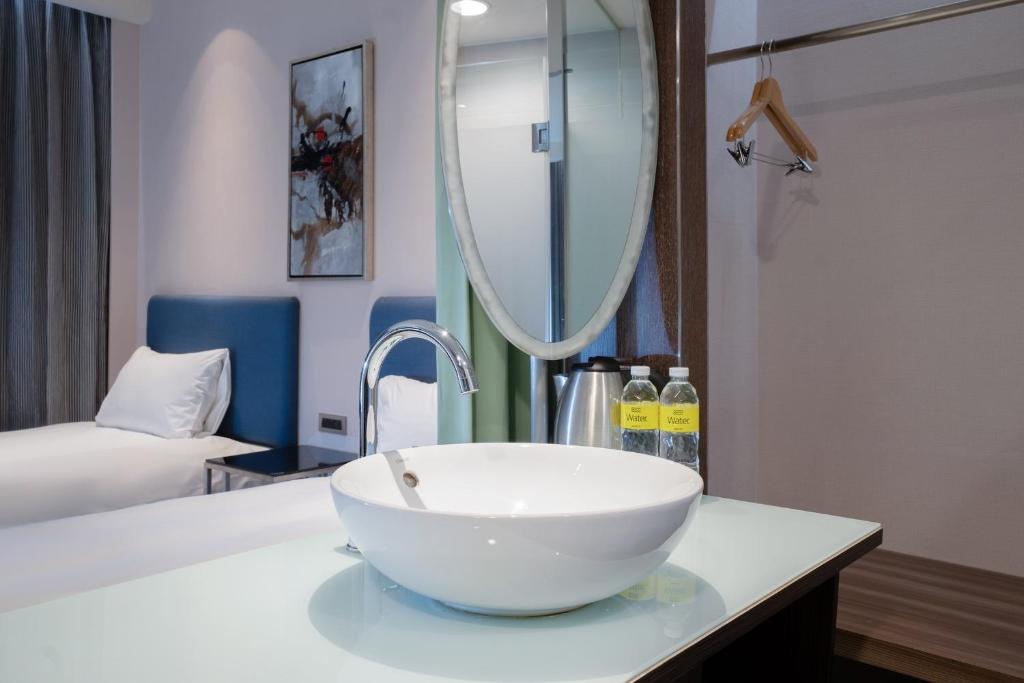 a bathroom with a bowl sink and a mirror at CHECK inn Taipei Xinyi in Taipei