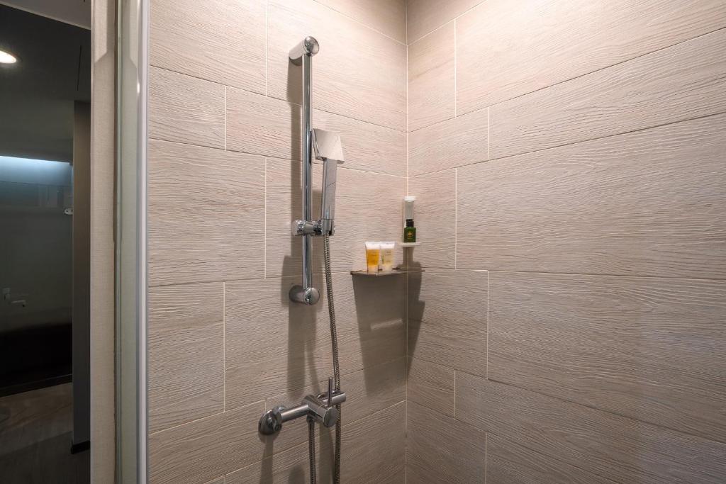 a shower with a glass door in a bathroom at CHECK inn Taipei Xinyi in Taipei