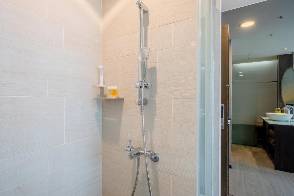 a shower stall in a bathroom with a sink at CHECK inn Taipei Xinyi in Taipei