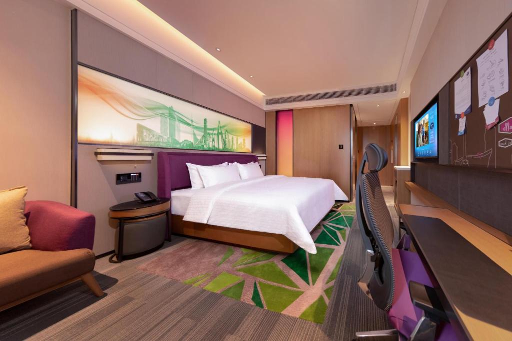 成都市にあるHampton by Hilton Chengdu Xibo Cityのベッドとテレビ付きのホテルルーム