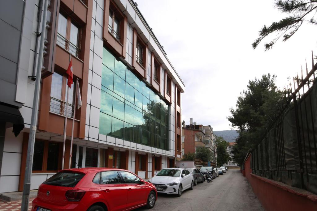 un coche rojo estacionado frente a un edificio en Hisarhan Otel en Amasya