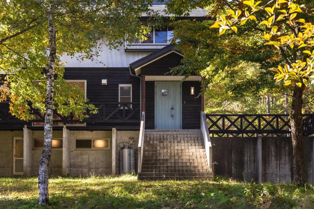 a house with a blue door and a fence at VILLA SHINANO in Shinano