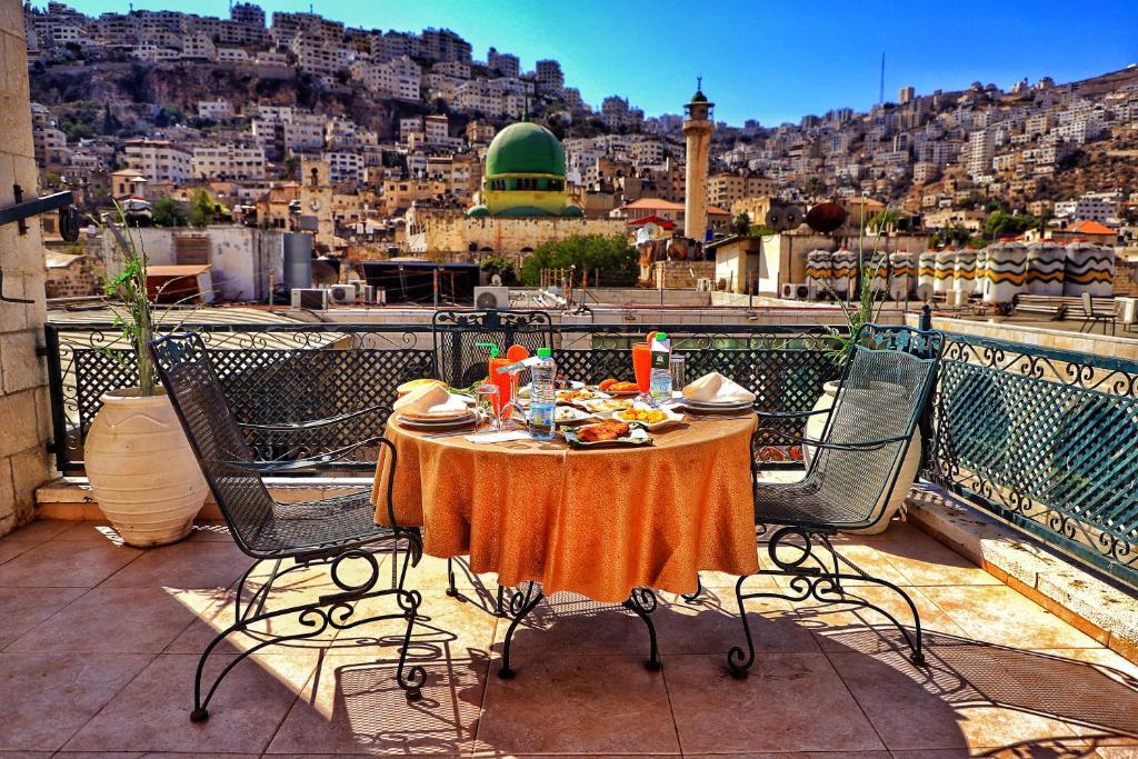 a table on a balcony with a view of a city at Al Yasmeen Hotel in Nablus
