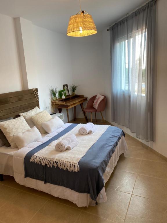 1 dormitorio con 1 cama grande y toallas. en Appartement Marquez, en Palomares