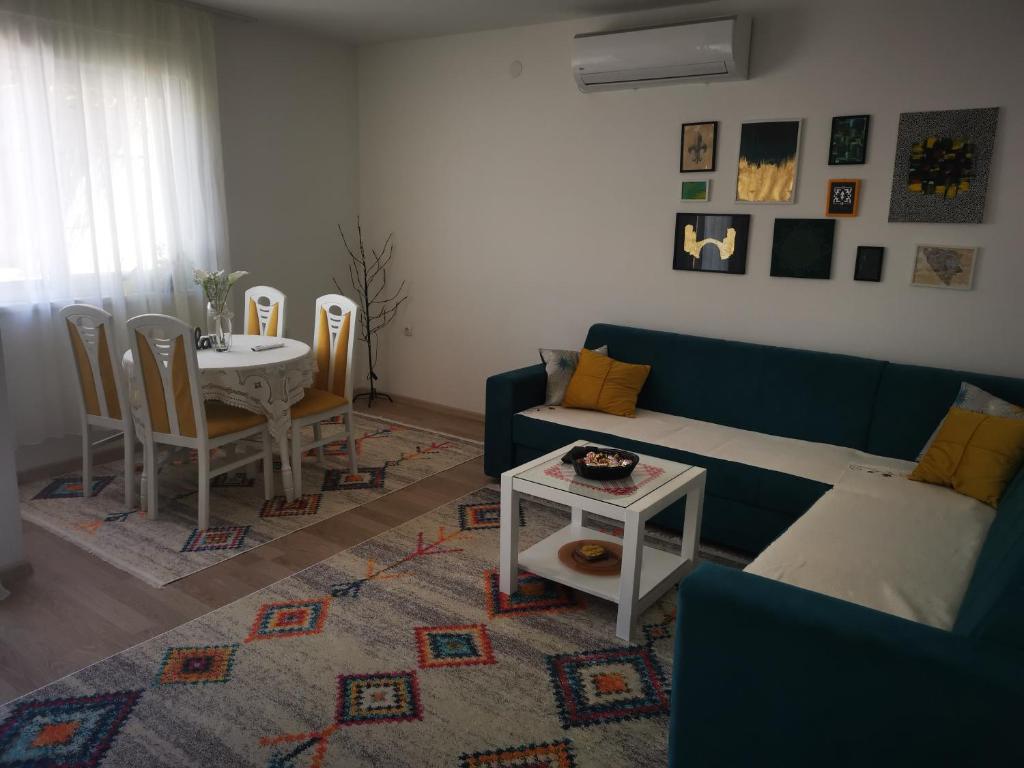 ein Wohnzimmer mit einem blauen Sofa und einem Tisch in der Unterkunft Apartman Dream House in Mostar
