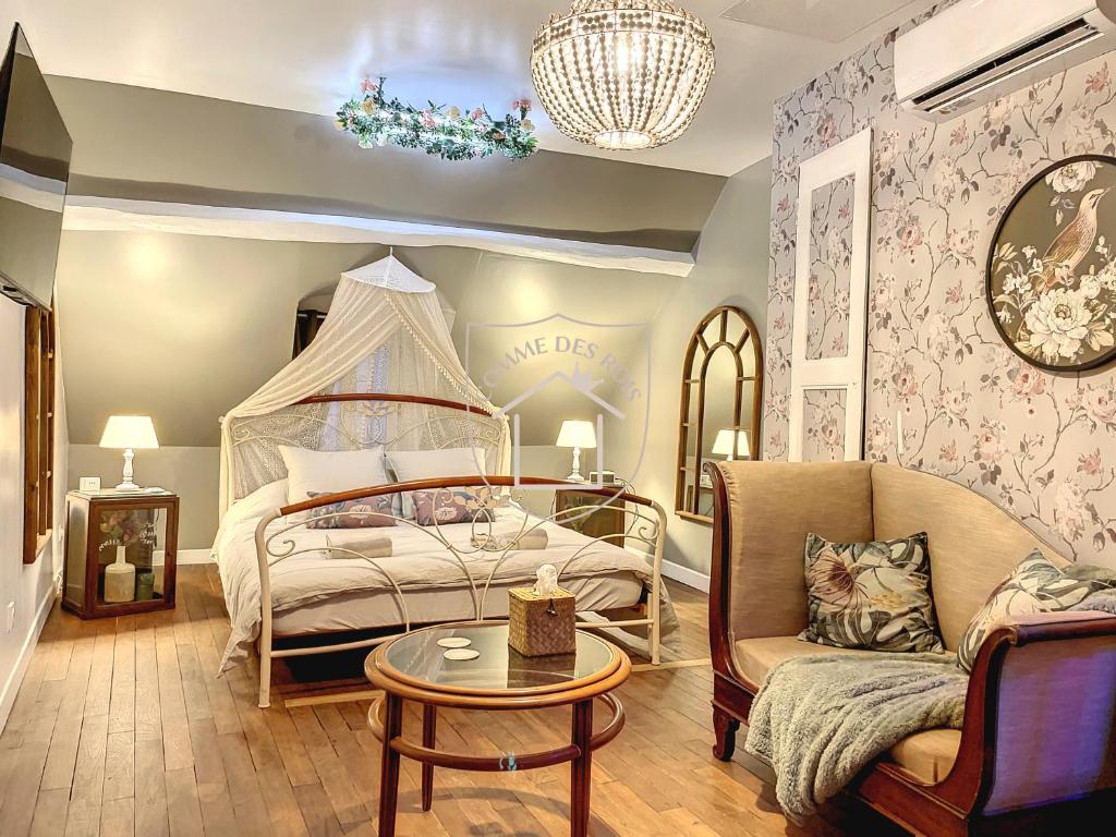een slaapkamer met een bed, een bank en een tafel bij La Romantique des Rois # Jacuzzi # Sauna in Dourdan