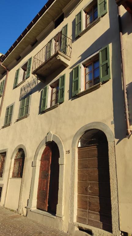 un edificio con due porte e un balcone di Pietra Viva - casa per vacanze a Chiavenna