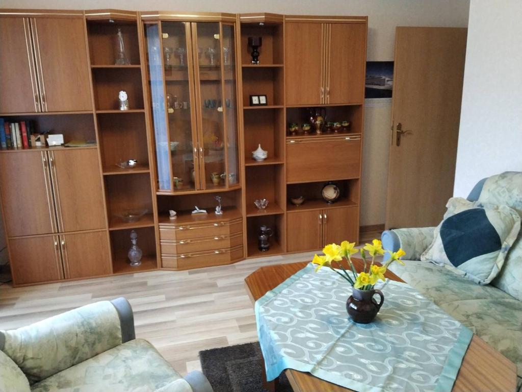 un salon avec une table avec des fleurs dessus dans l'établissement Ferienwohnung Kijas, à Wismar