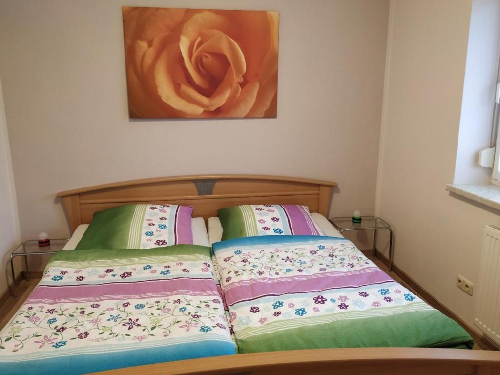 - un lit avec 2 oreillers et un tableau dans l'établissement Ferienwohnung Kijas, à Wismar