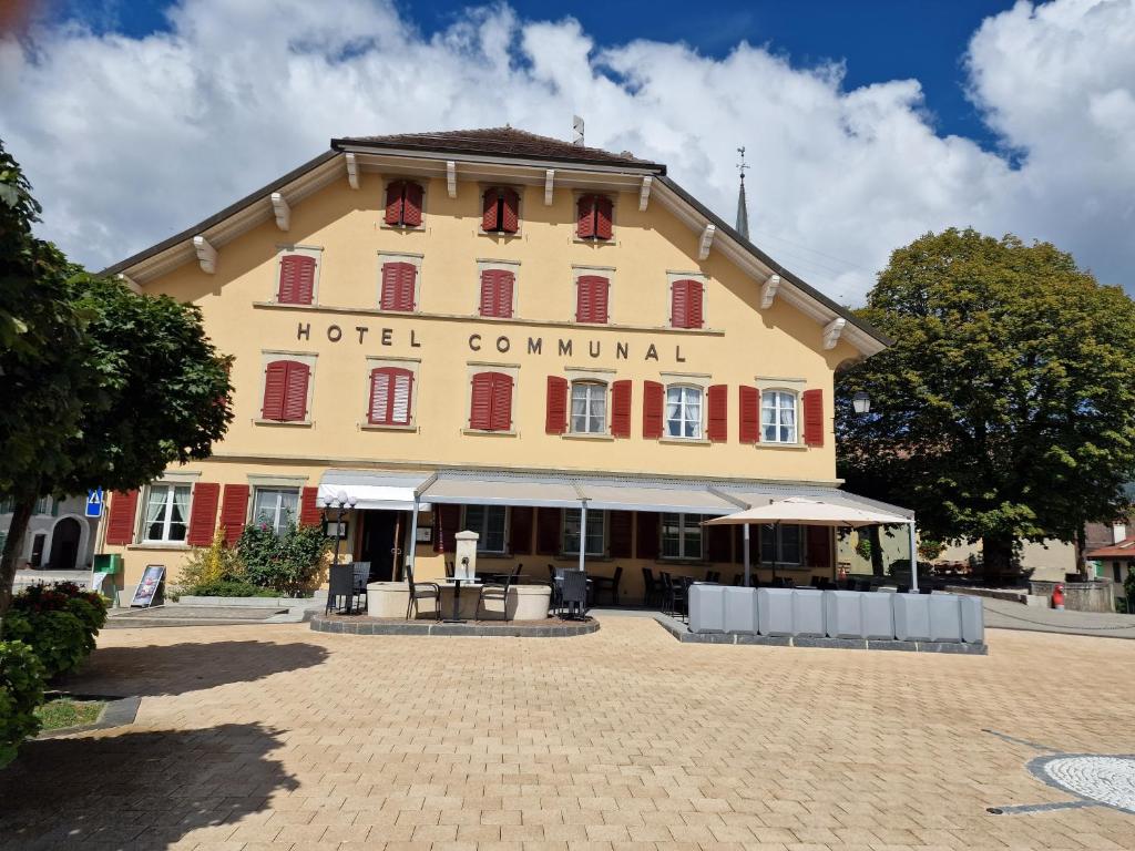 a large hotel building with red shuttered windows at Auberge de Ballens in Ballens