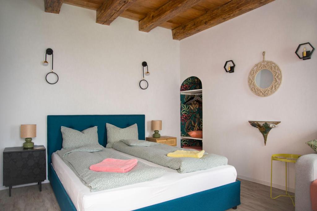 een slaapkamer met een bed met een blauw hoofdeinde bij Seek and Hide - Csilla's Tiny Hideaway in Braşov