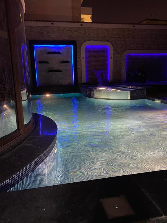 a swimming pool in a room with blue lights at black tiger villa in ‘Ezbet `Abd el-Ḥamîd