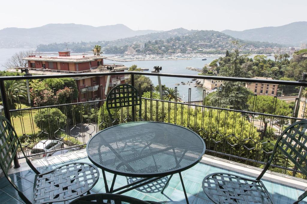 a table and chairs on a balcony with a view of the water at Poggio Fiorito in Rapallo