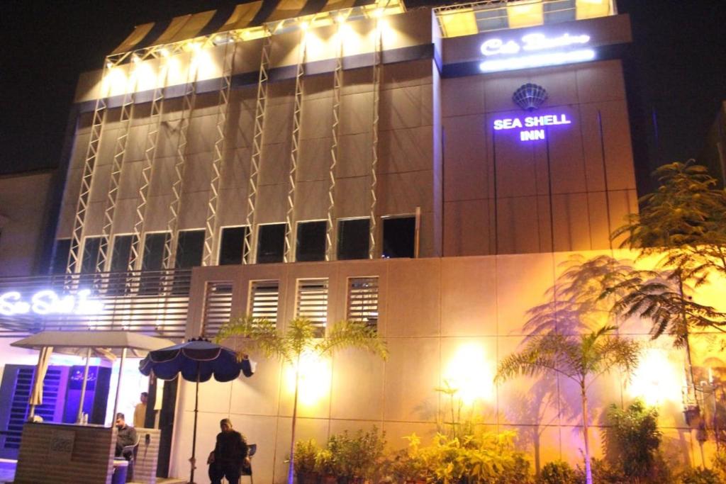 SEASHELLINN HOTEL في كراتشي: مبنى عليه علامة في الليل