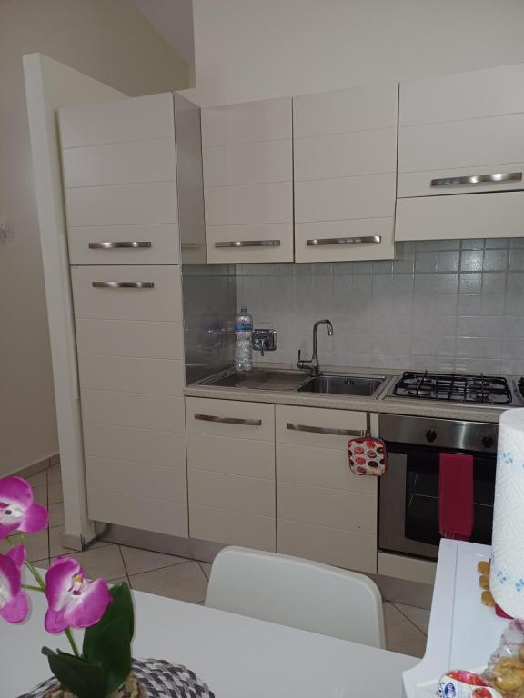 a kitchen with white cabinets and a sink at Monolocale Azzurra in Magione