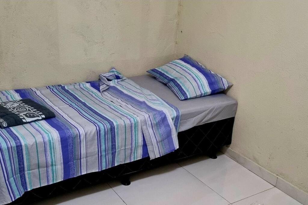 two beds sitting next to each other in a room at casa nova com ar condicionado in Pirapora