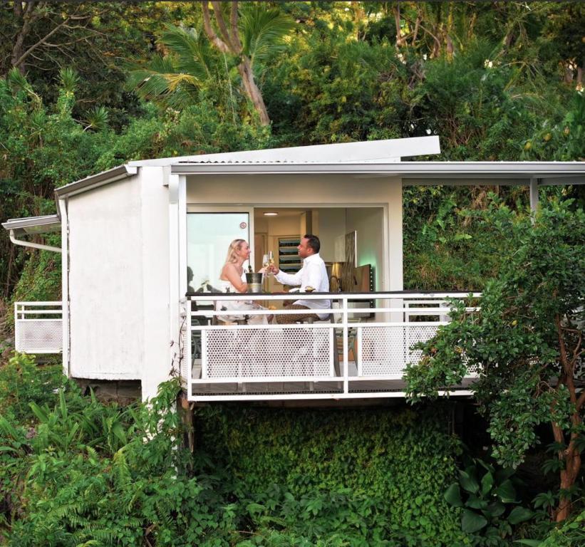 a couple standing on the balcony of a house at "La Ravine" privé, luxe, avec une vue unique in Saint-Joseph