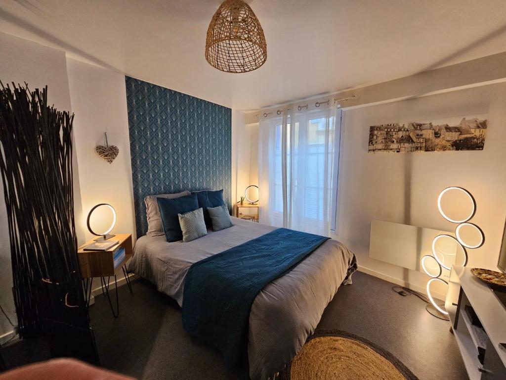 - une chambre avec un lit et un mur bleu dans l'établissement L'Appart'Mans -charmant-studio-centre ville-2 pers, au Mans