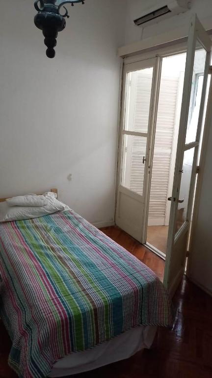 Schlafzimmer mit einem Bett und einer Glasschiebetür in der Unterkunft Cordón in Montevideo