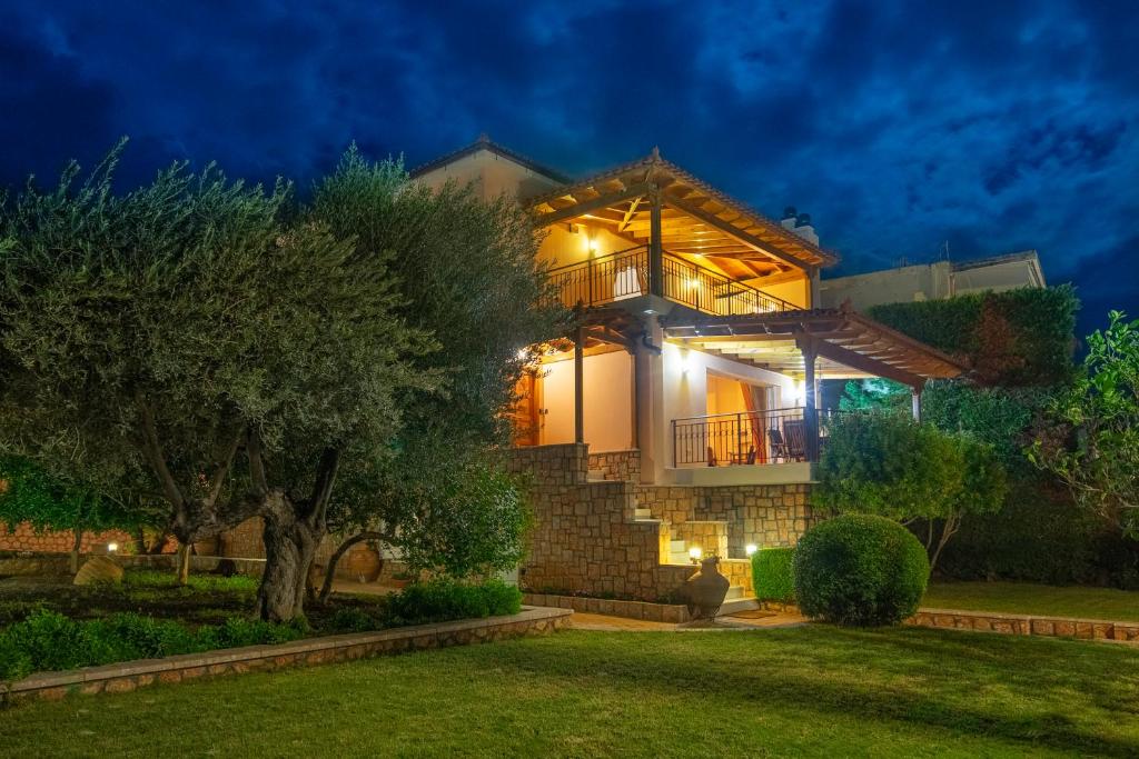 Una casa de noche con las luces encendidas en Villa Pasithea, en Korfos