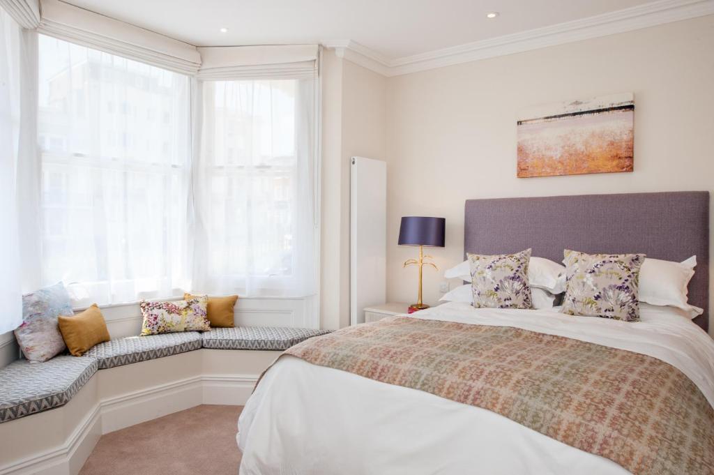 a white bedroom with a large bed and a window at The Charm Brighton Boutique Hotel & Spa in Brighton & Hove