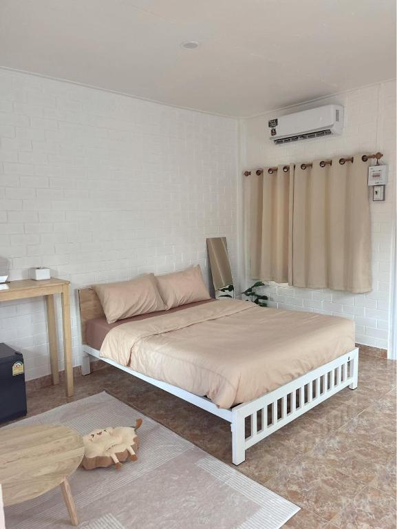 a bedroom with a large bed and a table at DE VARIS KHAOKHO in Ban Non Na Yao