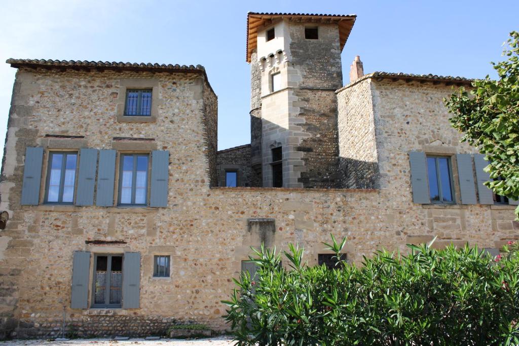 un antiguo edificio de piedra con una torre en la parte superior en Les Gîtes de Genas, en Bourg-lès-Valence