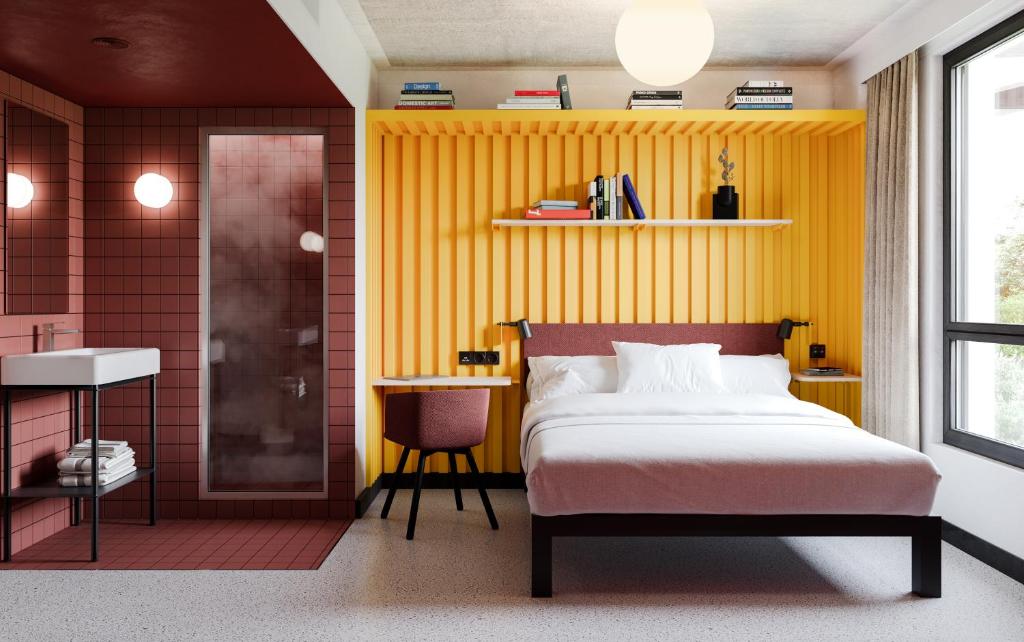 a bedroom with a bed and a yellow wall at JOST Hôtel Le Havre Centre Gare in Le Havre