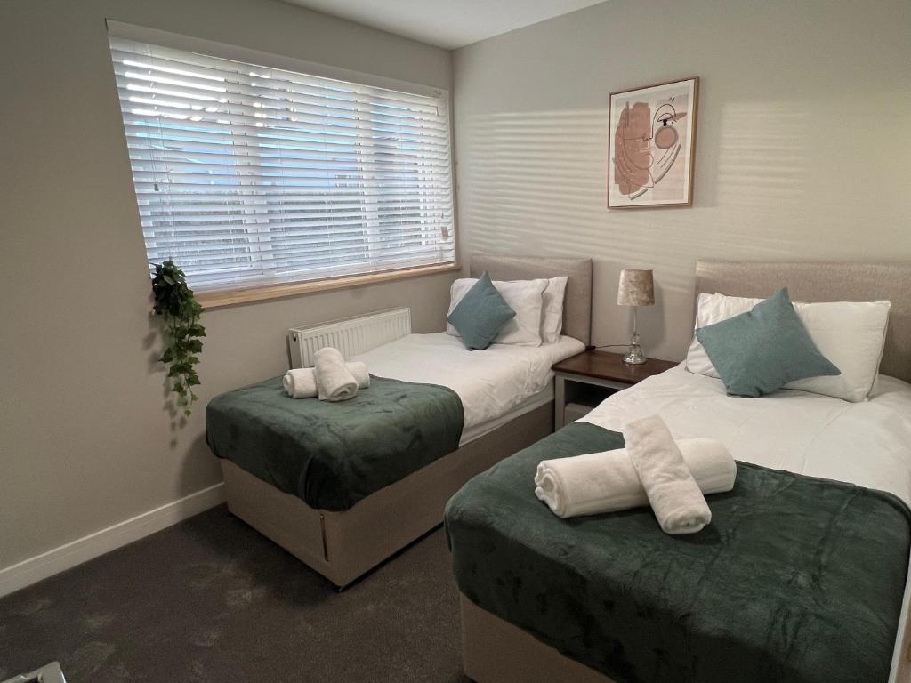a bedroom with two beds and a window at Immaculate Newly Refurbished 4 Bed House in Nottingham