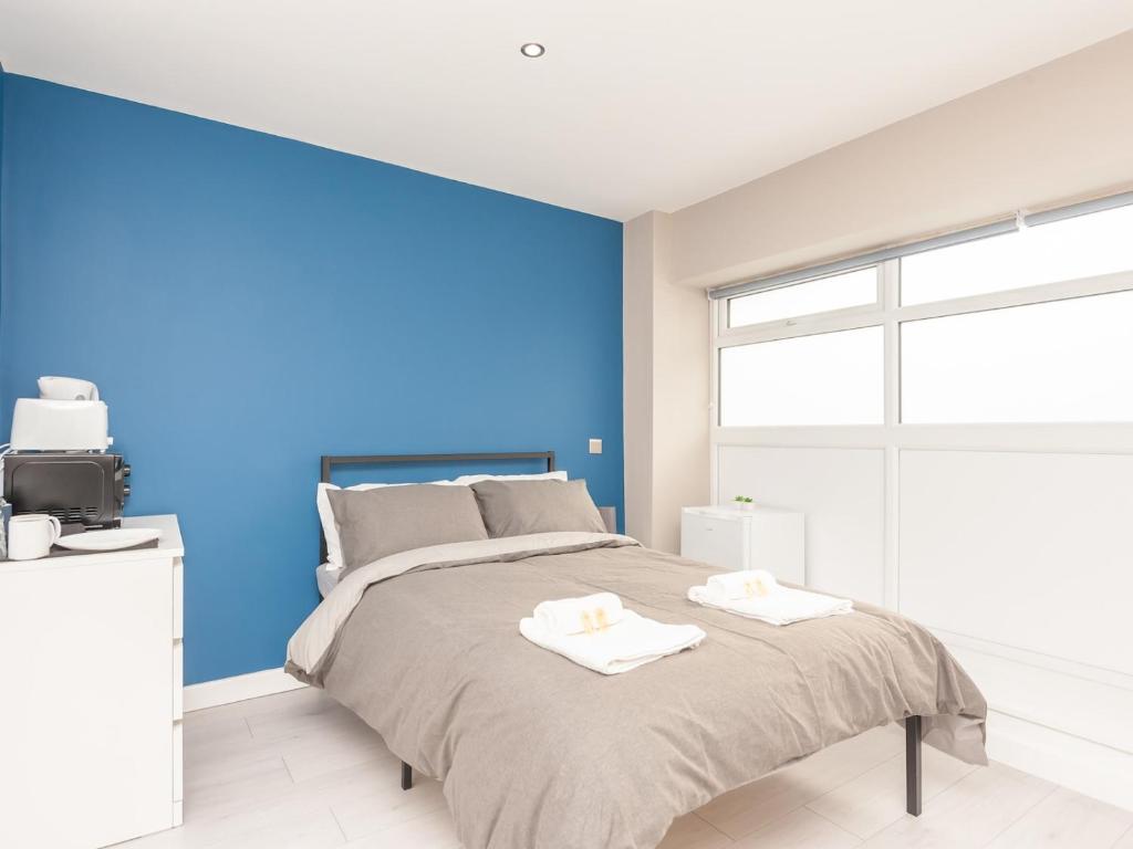 1 dormitorio con 1 cama grande y pared azul en Pass the Keys Burnley Central Hub Stylish Stay en Burnley