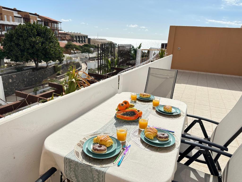 una mesa con platos de comida en el balcón en Ocean Duplex, en San Miguel de Abona