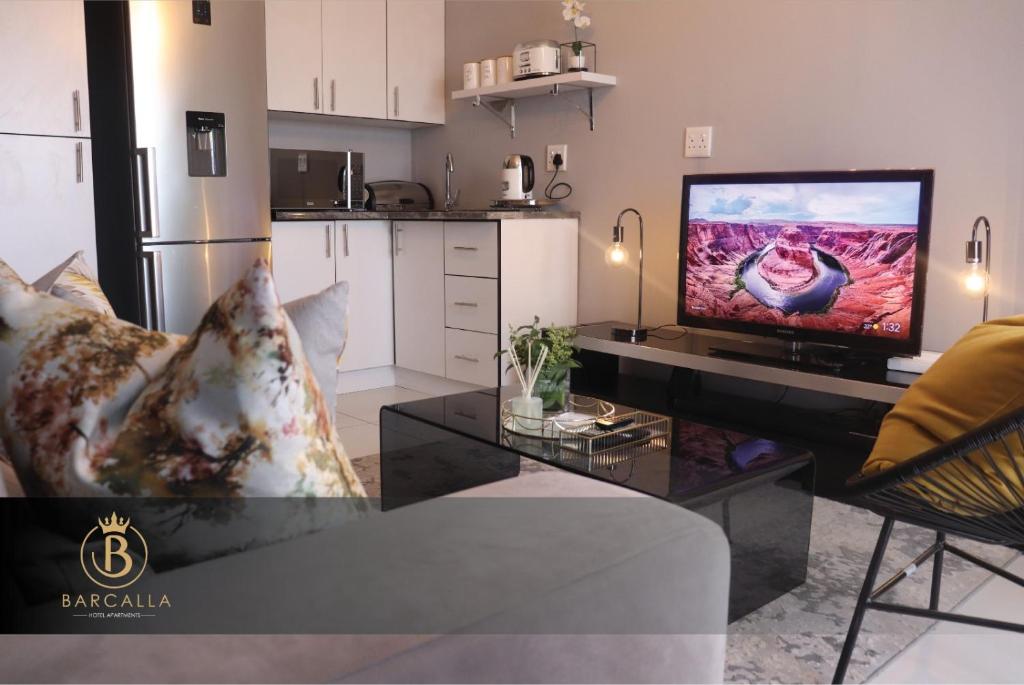 een woonkamer met een televisie op een tafel bij Barcalla Hotel Apartments in Maseru