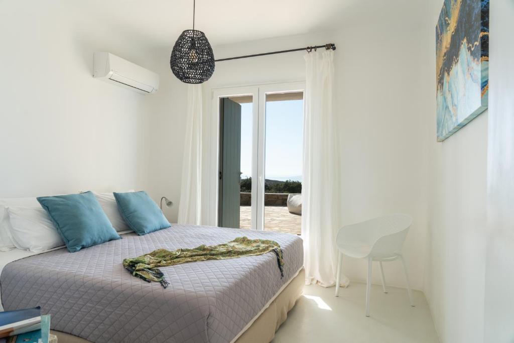 ein Schlafzimmer mit einem Bett und einem Tisch und einem Fenster in der Unterkunft Villa Crystal by Mykonos Mood in Fanari