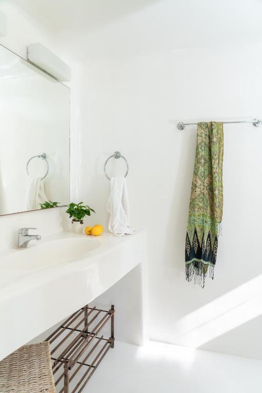 ein weißes Badezimmer mit Waschbecken und Spiegel in der Unterkunft Villa Crystal by Mykonos Mood in Fanari