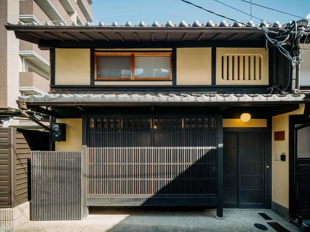 uma casa com um portão e um edifício em Sumire-an Machiya House em Quioto