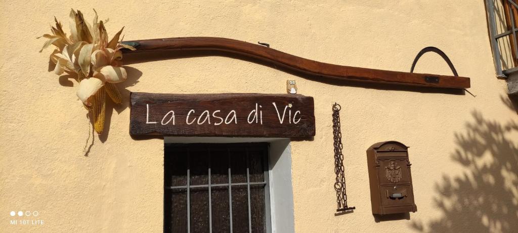 een bord aan de zijkant van een gebouw met een deur bij La casa di Vic in Levice