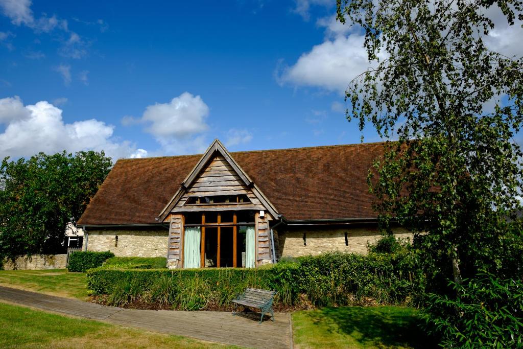 a stone house with a bench in front of it at Sabine Barn in Oxford