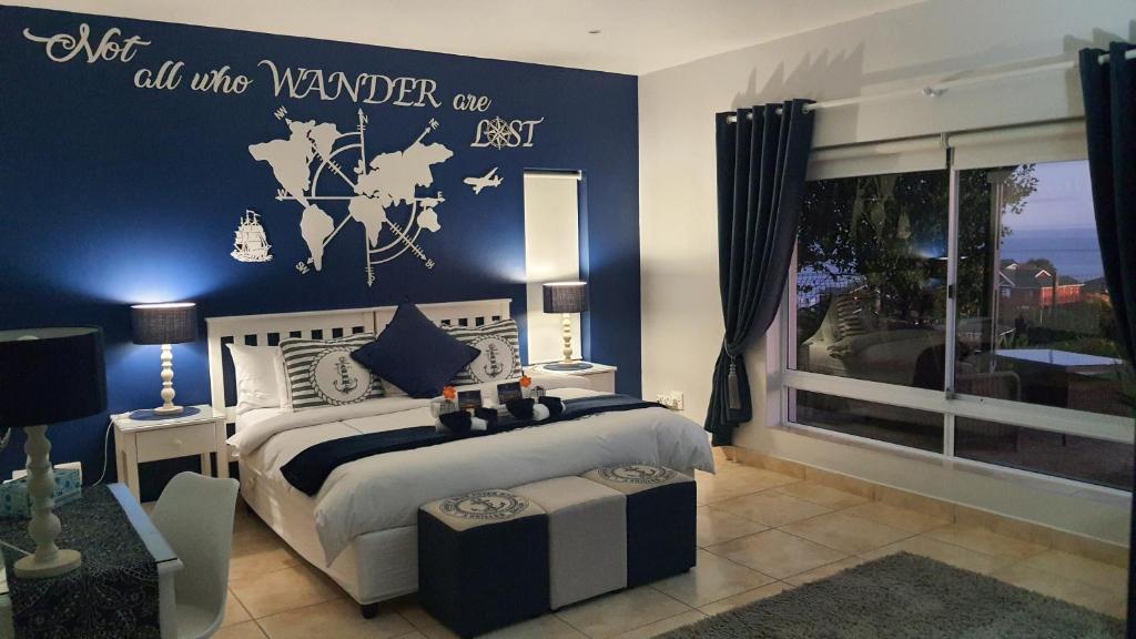um quarto com uma cama com uma parede azul em Amelia's by the Sea em Groot Brak Rivier