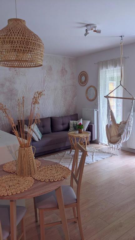 ein Wohnzimmer mit einem Tisch und einem Sofa in der Unterkunft Apartament&SPA Lis&Las in Sobótka