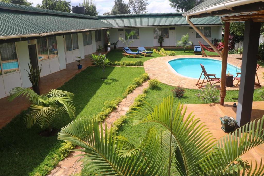 a backyard with a swimming pool and a house at Karanga River Lodge in Moshi