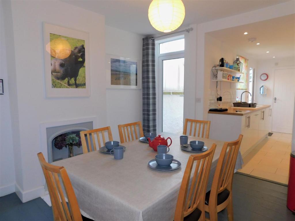 a dining room and kitchen with a table and chairs at Repton Cottage in West Runton