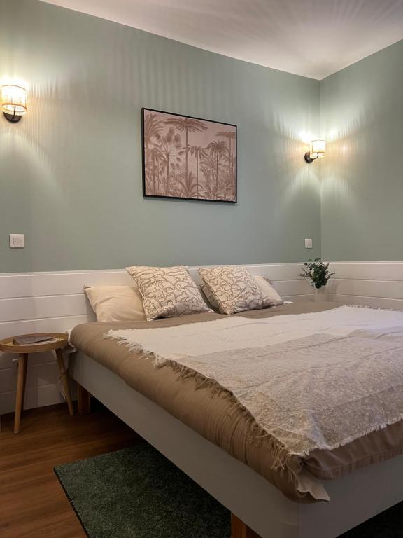 a bed in a room with two lights on the wall at L'Harmony in Saint-Arnoult-en-Yvelines
