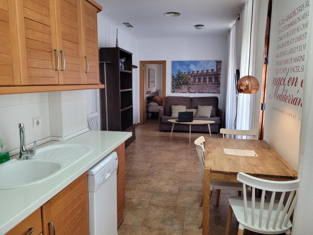a kitchen with a sink and a living room at Living Valencia Apartments - Merced in Valencia