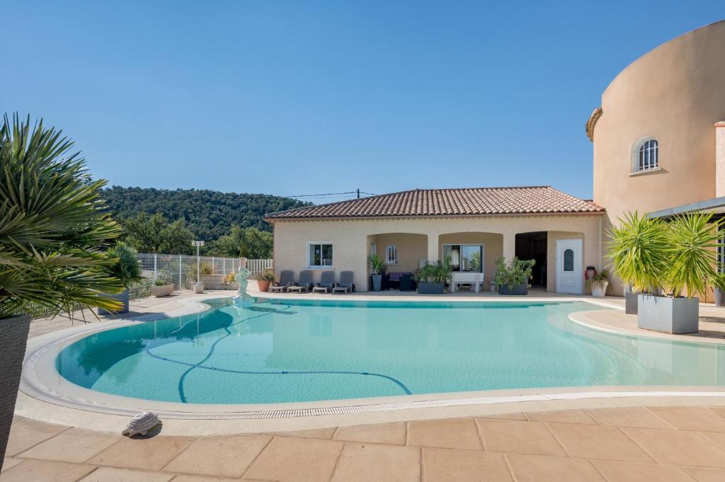 une grande piscine devant une maison dans l'établissement Villa Entre Mer Et Montagnes, à Montesquieu