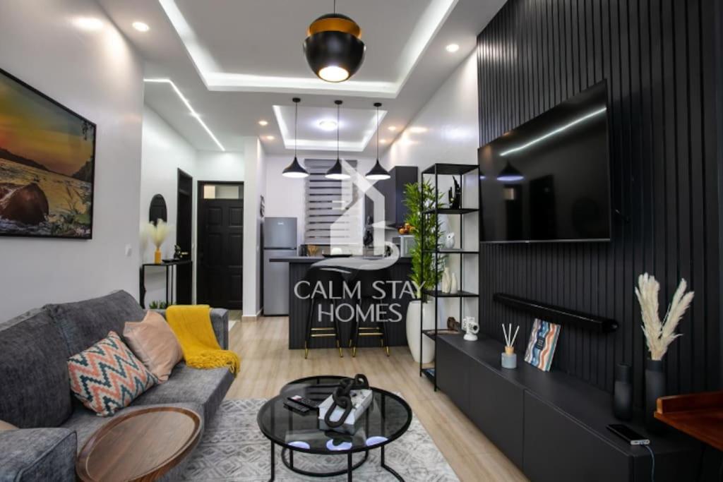 a living room with a couch and a tv at The Gray Haven Lakeside Condo in Entebbe in Entebbe